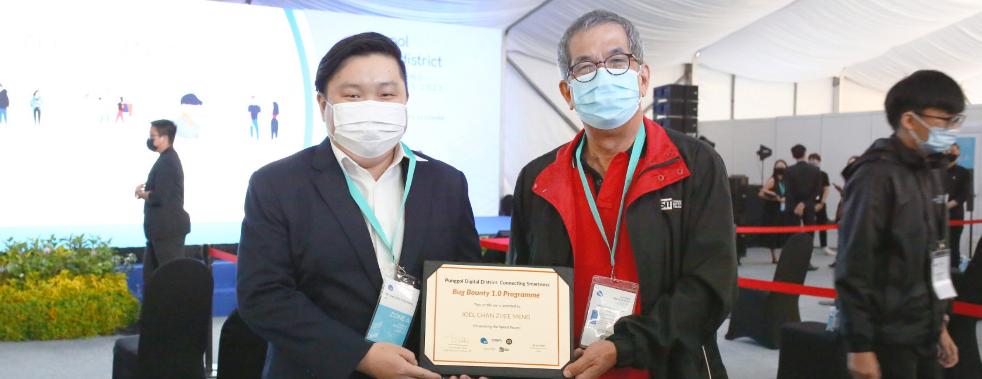 Joel Chan (left), together with Prof Tan Thiam Soon, Institute Professor, SIT, at the ‘PDD: Connecting Smartness’ event on 28 July 2021. Joel won the speed round of the PDD Bug Bounty, where he uncovered the first vulnerability in less than 10 minutes.