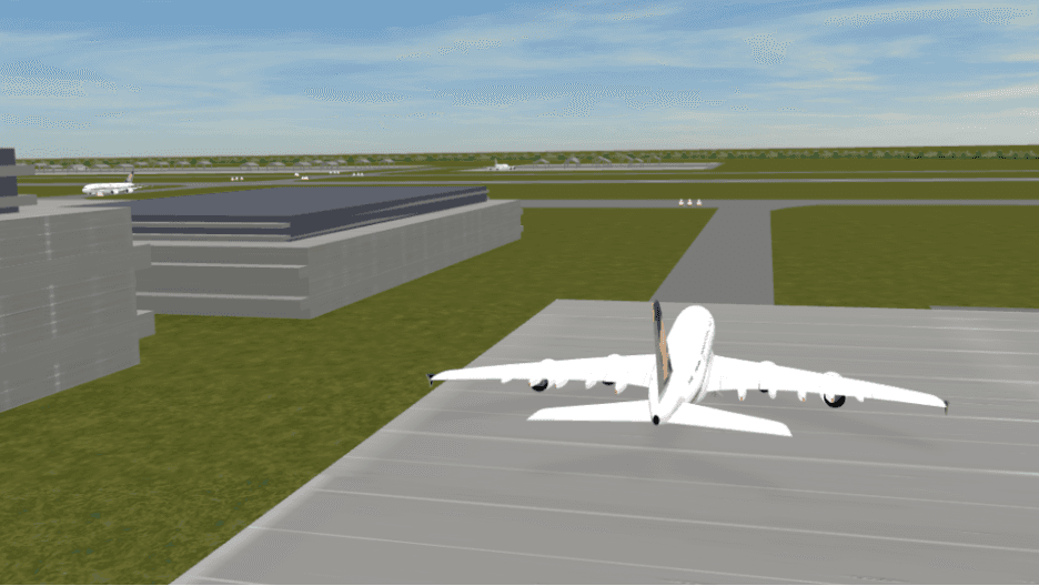 A 3D flight simulation environment showing a large commercial aircraft on a taxiway at an airport. Other planes and airport hangars are visible in the background under a clear sky.