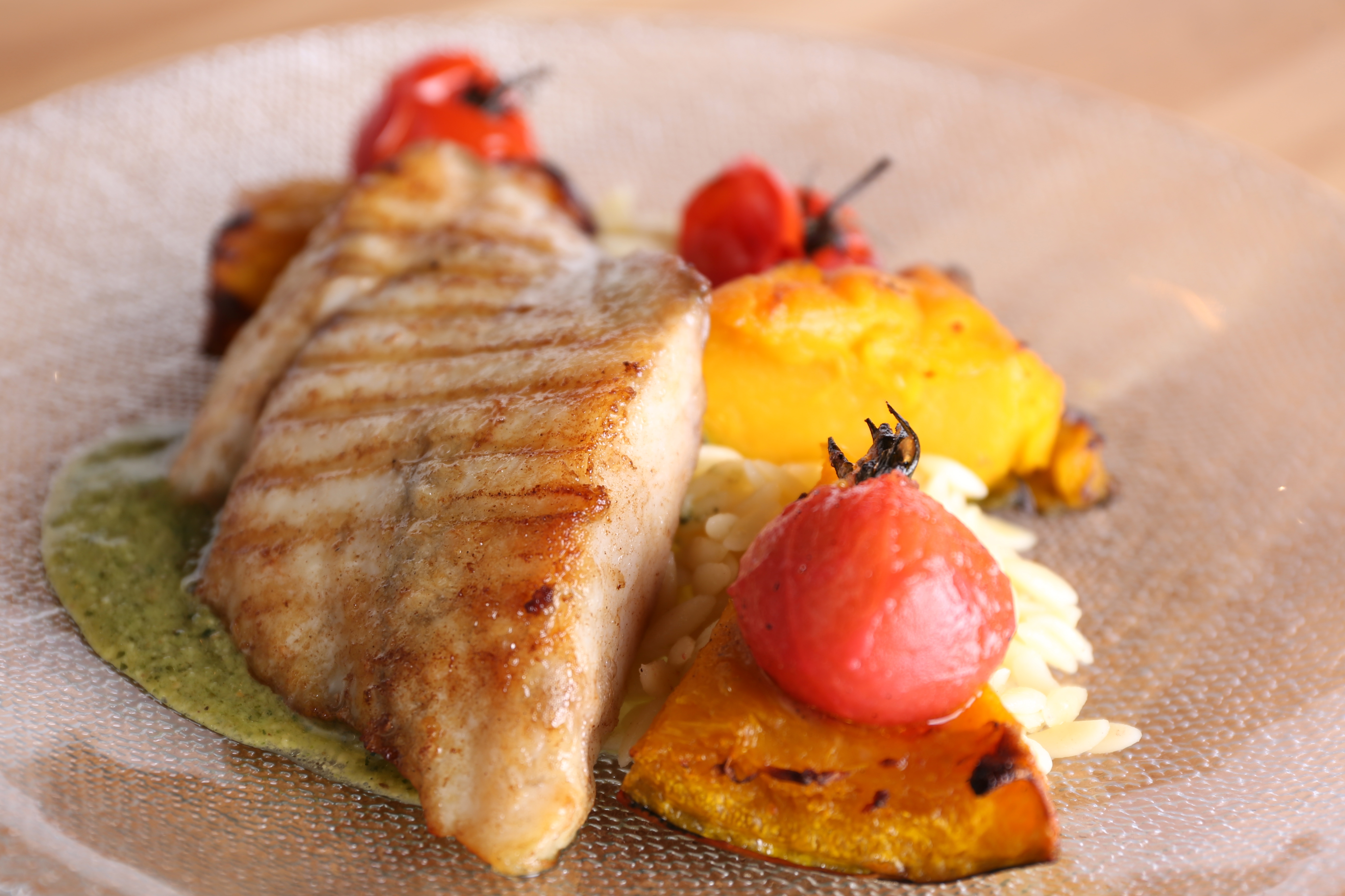 Barramundi roasted with brown butter, risoni, pesto, pumpkin and vine tomatoes.